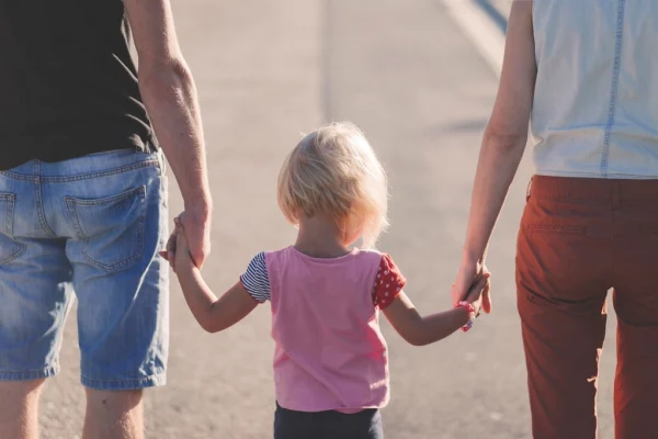 Free parent holding child's hand